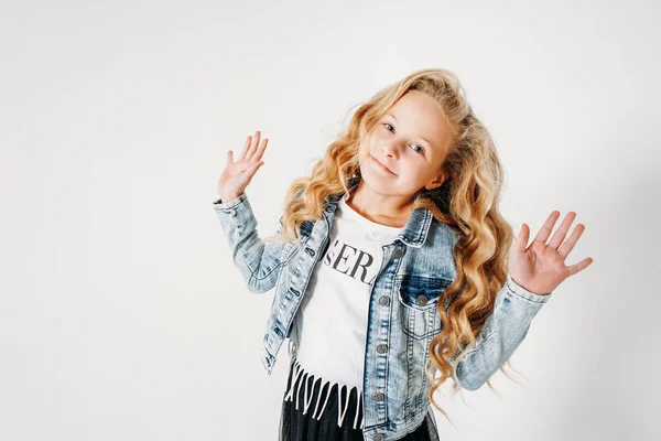 Smiling curly hair tween girl in denim jacket and black tutu skirt with raised hands on white background isolated — ストック写真