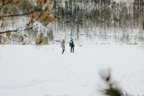Mladý pár s psí haski v lesním přírodním parku v zimě. Koncept dobrodružství na cestách — Stock fotografie