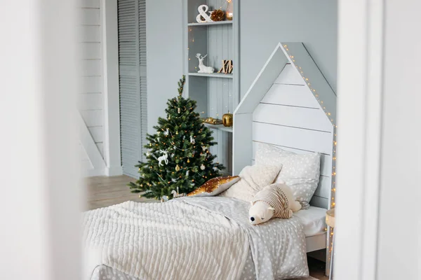 A cama de crianças de madeira com travesseiros e brinquedos. Decoração minimalista de Natal. Interior escandinavo — Fotografia de Stock