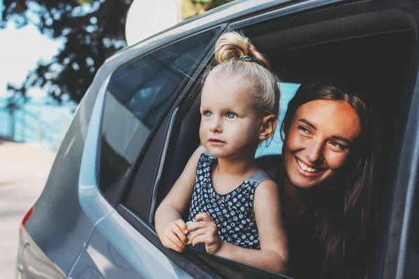 Petit bébé tout-petit fille regarde par la fenêtre de la voiture avec sa mère — Photo