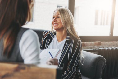 Young successful women colleagues discuss joint project, coachin