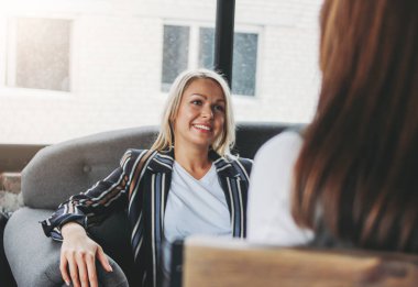 Young successful women colleagues discuss joint project, coachin