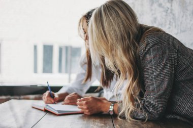 Young successful women colleagues discuss joint project, coachin