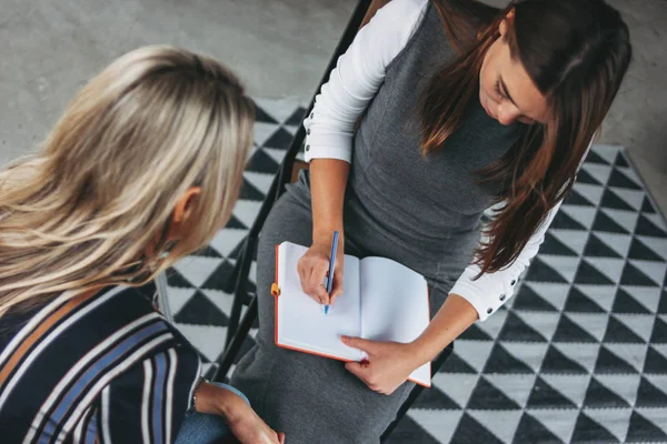 Jovens colegas mulheres bem sucedidas discutir projeto conjunto, coaching ou mentoring no escritório loft moderno — Fotografia de Stock