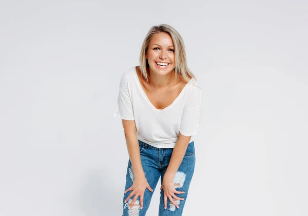 Blonde hair happy woman 35 year plus in white t-shirt and blue jeans isolated on white background — 스톡 사진