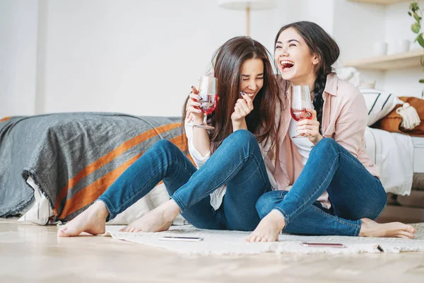 Jovens despreocupados rindo morena meninas amigos no casual com copos de vinho se divertindo juntos na festa em casa — Fotografia de Stock
