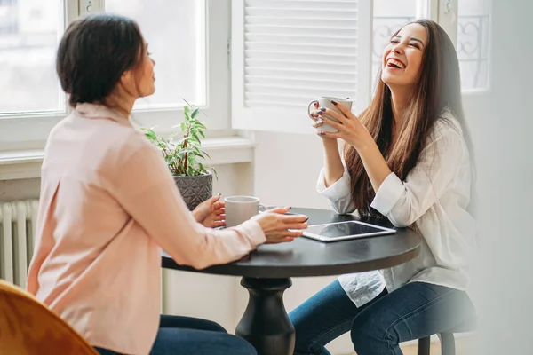 Jonge zorgeloze brunette meisjes vrienden in casual met koppen thee — Stockfoto