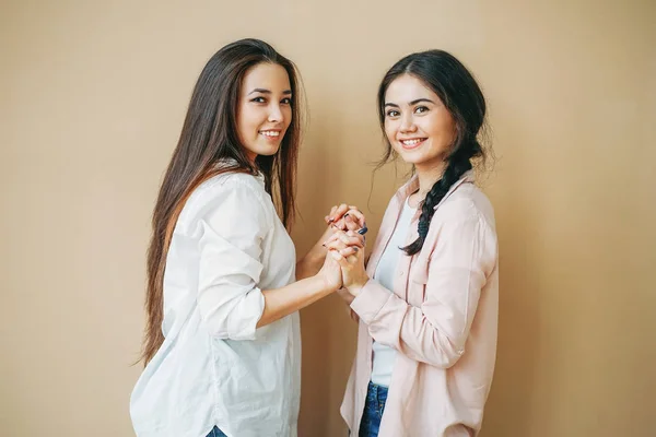 Jeunes filles souriantes amis étudiants en casual isolé sur fond beige — Photo