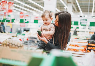 Genç bir kadın annesi ve küçük bir çocuğu var. Süpermarketten freshavokado alıyor.