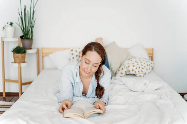 Amigável Mulher Morena Encantadora Ler Livro Cama Interior Brilhante — Fotografia de Stock