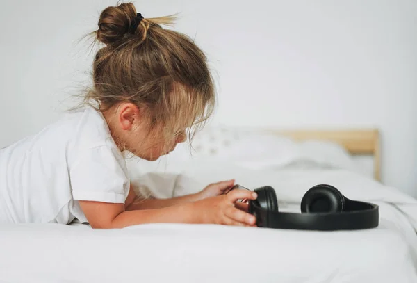 Linda Niña Con Pelo Claro Con Auriculares Con Móvil Cama — Foto de Stock