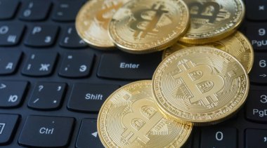 Golden Bitcoins on a laptop keyboard. Cryptocurrency clipart