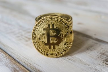 Ahşap bir masa üzerinde altın Bitcoins. Fotoğraf yeni sanal para