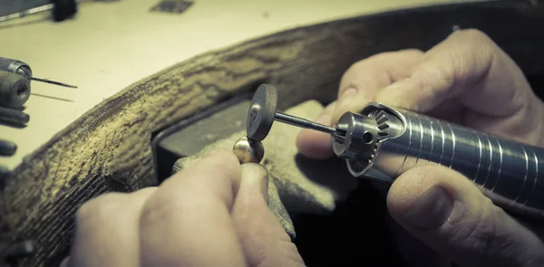 Der Juweliermeister in der Werkstatt verarbeitet den Schaft für den weiblichen Schmuck — Stockfoto