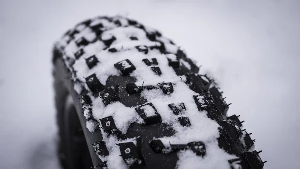 Primer plano de la pisada en un neumático de bicicleta de montaña grasa en la nieve  . —  Fotos de Stock