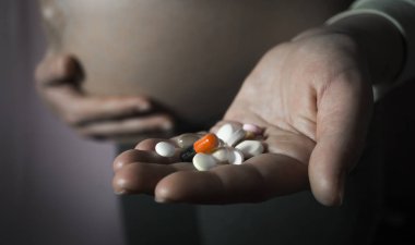 tanınmayacak halde hamile kadının elinde haplar ile yakın çekim