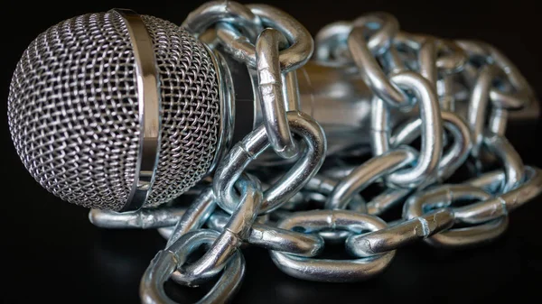 Microphone and chain. Freedom of the press is at risk concept - World press freedom day concept