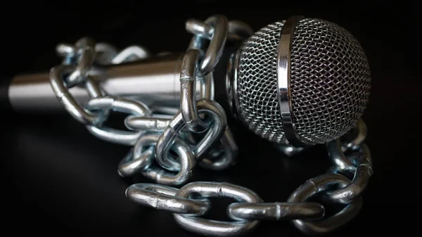 Microphone and chain. Freedom of the press is at risk concept - World press freedom day concept