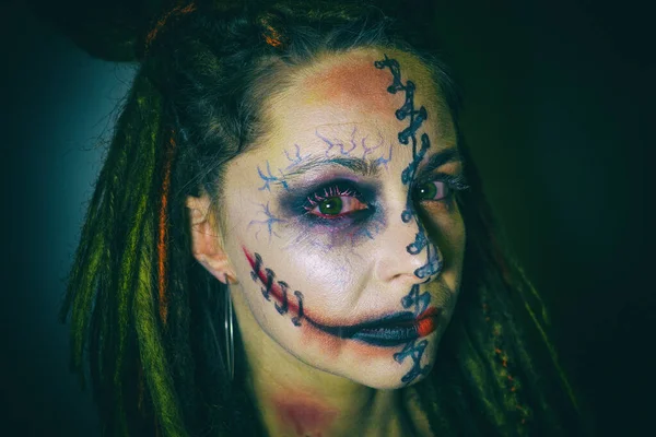 Sexy heks met Halloween make-up. Een griezelige vrouwelijke Halloween make-up van een heks met een bloederig gezicht. Jonge mooie vrouw met stijlvolle make-up — Stockfoto