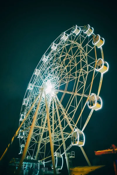 Rueda Ferris en el parque de atracciones. Parte de la rueda de los hurones sobre un fondo de cielo nocturno con iluminación nocturna —  Fotos de Stock