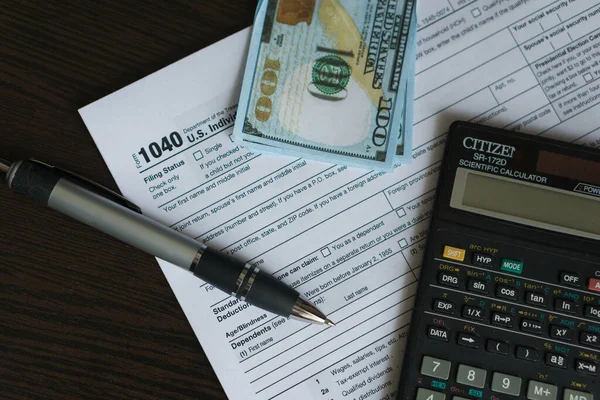 Concepção empresarial e fiscal. Formulário fiscal 1040, caneta e calculadora na mesa. Conceito de tributação — Fotografia de Stock