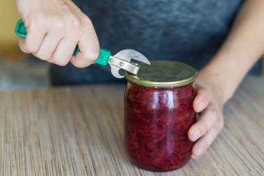 Eski tarz bir konserve açacağıyla mutfakta konserve açan kadına yakın çekim..