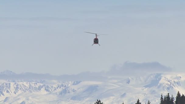 Helikoptern flyger till snöiga alaskan bergen — Stockvideo