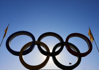 Nicopol, Ukrayna - 9 Kasım 2019: Mavi gökyüzünün arka planında Olimpiyat halkaları. Olimpiyatların halkalarında bayraklar, gökyüzünde uçan kuşlar var..