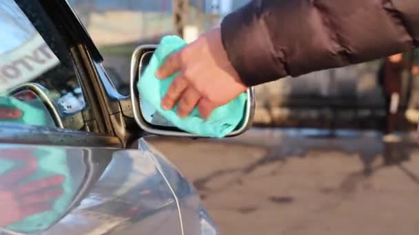 マイクロファイバーを使用している男は車のサイドミラーを拭く 車のケアの概念 — ストック動画