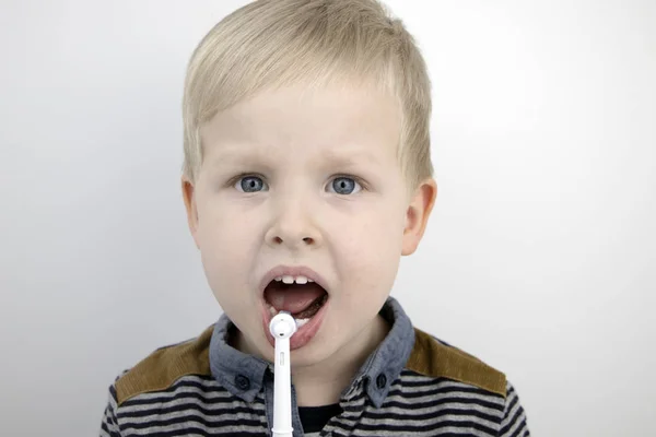 Чотирирічна Дитина Чистить Зуби Електричним Пензлем Хлопчик Білому Тлі Сміється — стокове фото