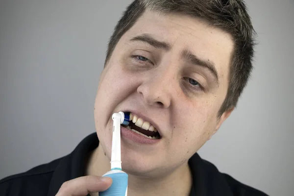 Schläfriger Mann Putzt Seine Zähne Mit Einer Elektrischen Bürste Mundhygienekonzept — Stockfoto