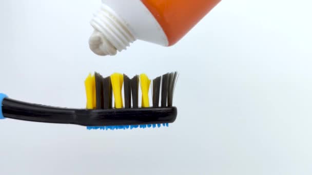 Weiße Zahnpasta Wird Sanft Aus Der Tube Auf Eine Dunkelblaue — Stockvideo