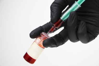 Şırınga ve test tüpü kapatın. Doktor kan tahlili yapıyor. Kan testlerinin yapıldığı laboratuvar. Metin için beyaz arkaplan ve yer.