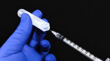 Doktor, bir plastik ampulden insülin şırıngası ile aşı için bir ilaç ya da madde alıyor. Tıbbi ekipmanların makro videosu.