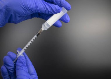Doktor, bir plastik ampulden insülin şırıngası ile aşı için bir ilaç ya da madde alıyor. Tıbbi ekipmanların makro videosu.