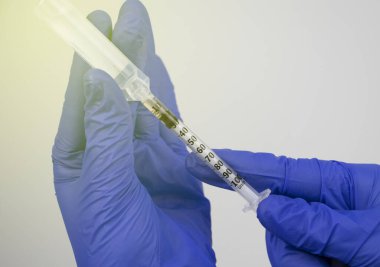 Doktor, bir plastik ampulden insülin şırıngası ile aşı için bir ilaç ya da madde alıyor. Tıbbi ekipmanların makro videosu.