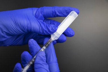 Doktor, bir plastik ampulden insülin şırıngası ile aşı için bir ilaç ya da madde alıyor. Tıbbi ekipmanların makro videosu.