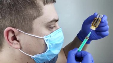 Doktor şırıngaya iğne yapıyor. Bir erkek doktor bir hastaya aşı enjekte etmek üzere. Nüfusun aşılanması ve aşılanması kavramı