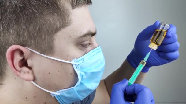 医者は注射器に注射をする 男性医師が患者にワクチンを注射しようとしている 予防接種と予防接種の概念 — ストック動画