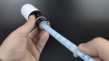 Oral kullanım için plastik bir şırıngada sıvı antipiretik toplanır. Ateşli bir ilacın makro videosu.