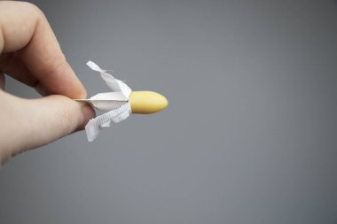 Vajinal ya da rektal mum ellerde ve arka planda. İlaç, fitiller şeklinde üretilmiştir. Jinekolojik hastalıkların tedavisi ve rektum hastalıklarının tedavisi