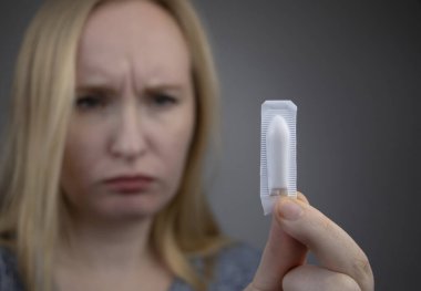 Vajinal ya da rektal fitil bir kadının elinde. İlaç, fitiller şeklinde üretilmiştir. Jinekolojik hastalıkların tedavisi ve rektum hastalıklarının tedavisi