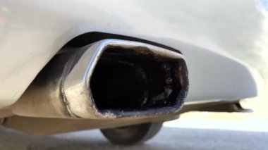 Çalışan bir araba susturucusu. Titreşen araba egzoz sisteminin makro videosu. Dünyanın CO2 kirliliği