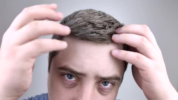 Молодой Человек Перед Зеркалом Рассматривает Свои Ранние Седые Волосы Концепция — стоковое видео