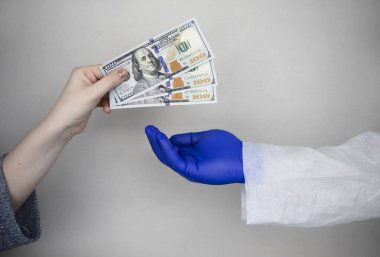Hastanın eli doktora para uzatıyor. Sağlık hizmetlerinde yolsuzluk, rüşvet veya ücretli ilaç kavramı