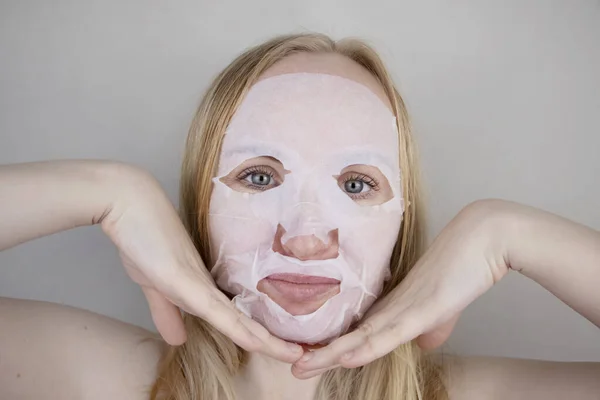 一个快乐而有趣的女孩带着润肤的面罩鬼鬼祟祟 晨美治疗 油性和混合性皮肤护理概念 — 图库照片