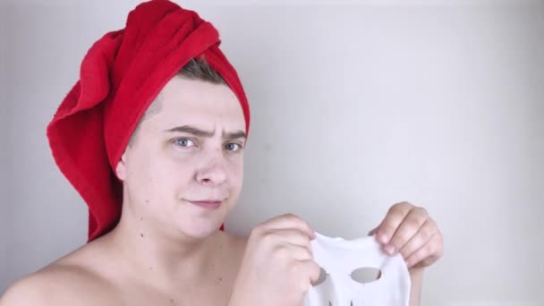Rolig Man Med Röd Handduk Sätter Återfuktande Tygmask Ansiktet Begreppet — Stockvideo