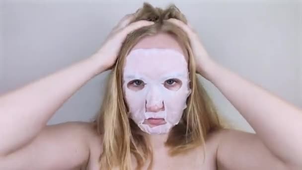 一个快乐而有趣的女孩带着润肤的面罩鬼鬼祟祟 晨美治疗 油性和混合性皮肤护理概念 — 图库视频影像