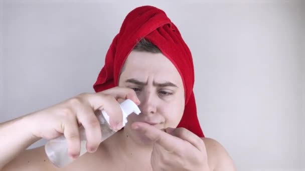 一个头上戴着红色毛巾的有趣男人照顾着自己的脸 用泡沫洗脸 男性自我护理 温泉治疗和男性化妆品的概念 — 图库视频影像