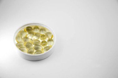 Beyaz arka planda D3 vitamini jelatin kapsülleri. Yağda çözünen güneş vitamini kolesiferol sarı parlar ve parlar. Metin için yer